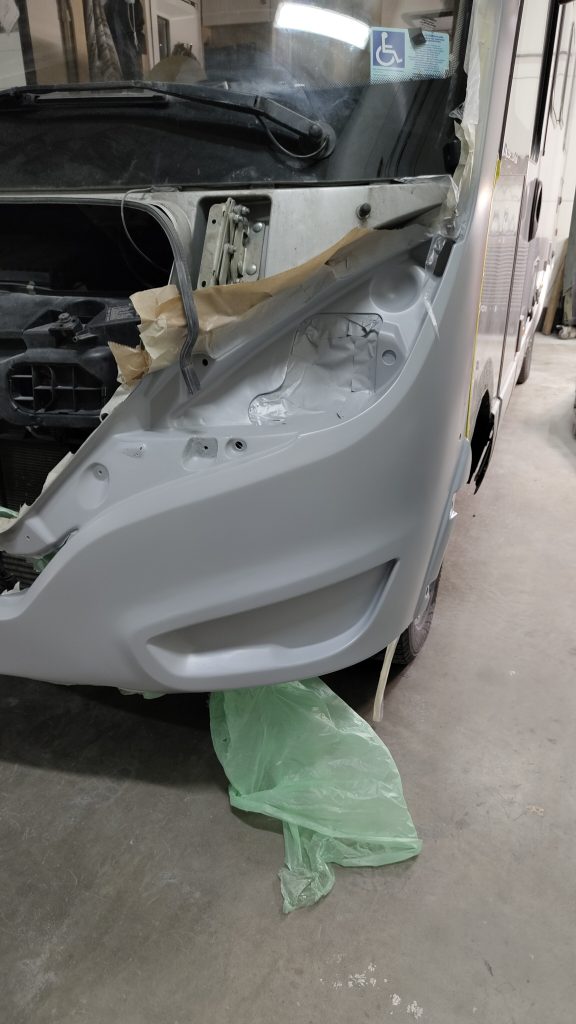 Sivulasi hajosi Helsingissä, autokorjaaja tarkastaa auton oven lasivauriota